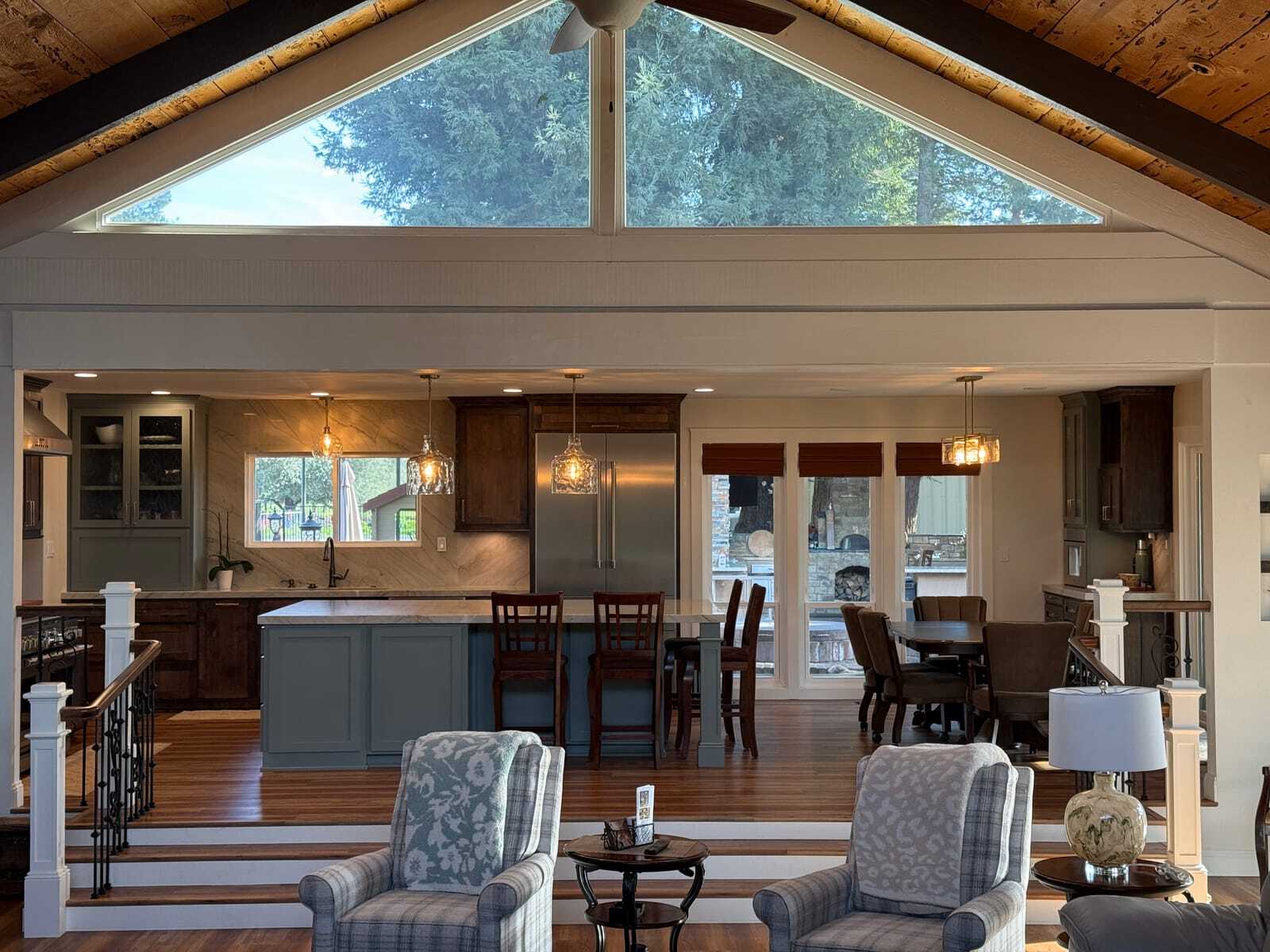 Vaulted great room with exposed timber beams opening onto a renovated kitchen